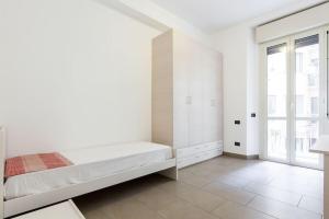 una camera da letto bianca con un letto e una finestra di Spacious and new apt in Città Studi a Milano
