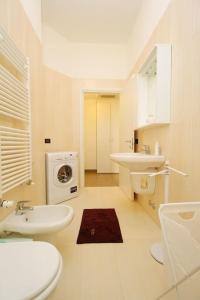 bagno bianco con lavandino e lavatrice di Spacious and new apt in Città Studi a Milano