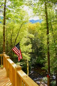 eine amerikanische Flagge auf einer Holzterrasse mit einem Fluss in der Unterkunft The Junction in Robbinsville