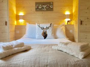 a bedroom with a bed with a deer head on it at Chalet Le Flocon Bleu - Mauselaine avec vue sur le Lac de Gérardmer in Gérardmer