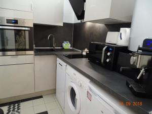 a kitchen with a washing machine and a microwave at Palm beach Cannes Azur in Cannes