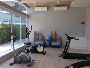 a gym with two treadmills and two exercise bikes at The Sea Condominium in Ban Nong Khaem