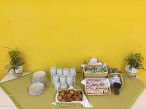 a table with plates and food on a yellow wall at Ecohotel La Casona Pereira in Pereira