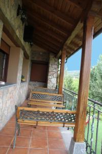 a group of benches sitting on a balcony at Hotel Rural Valle del Tuejar in Taranilla