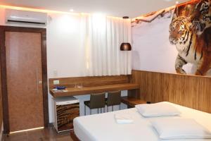 um quarto com uma cama e uma foto de um tigre na parede em Motel Fuego (Adults Only) em Betim