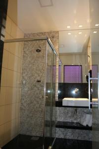 een badkamer met een douche en een wastafel bij Motel Fuego (Adults Only) in Betim
