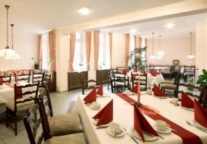 uma sala de jantar com mesas e cadeiras com guardanapos vermelhos em Hotel Goldener Stern em Ascheberg