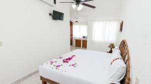 a bedroom with a white bed with flowers on it at Villa Lupita in Zihuatanejo