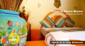 a room with a bed and a vase on a table at Hotel Brisas de Verano in San Juan de Alima