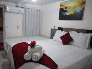 1 dormitorio con 2 camas y toallas. en Residência da Cláudia, en Fernando de Noronha