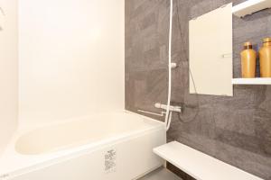 un bagno con una vasca bianca e un lavandino di Tourisakuraann 1goukann a Kyoto Altre 30 foto