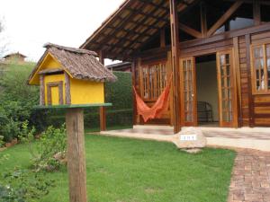 een huis met een vogelvoeder voor een huis bij Chalé Pura Vida in São Roque de Minas