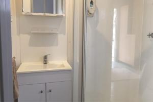 a white bathroom with a sink and a shower at Peppermint Grove Beach Holiday Park in Capel +20 photos