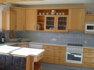 cocina con armarios de madera y horno con fogones en Appartement Gasser, en Anras