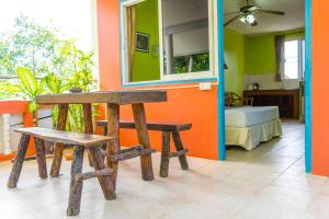 a room with a table and a bench and a bedroom at Chez Charly Bungalow in Nai Yang Beach