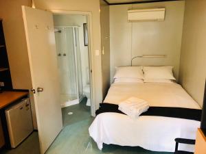a small bedroom with a bed and a shower at Peppermint Grove Beach Holiday Park in Capel