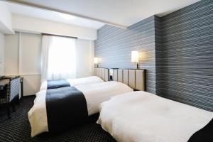a hotel room with two beds and a window at APA Hotel Sapporo Susukino Ekimae in Sapporo +69 photos