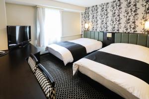 a hotel room with two beds and a television at APA Hotel Sapporo Susukino Ekimae in Sapporo +65 photos