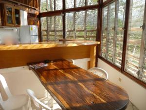 a kitchen with a wooden table and some windows at NuestraMadreTierra in La Esperanza