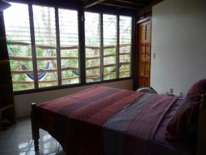 a bedroom with a bed in a room with windows at NuestraMadreTierra in La Esperanza +37 photos