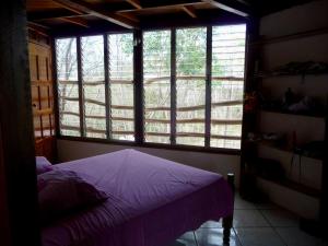 a bedroom with a bed and a large window at NuestraMadreTierra in La Esperanza