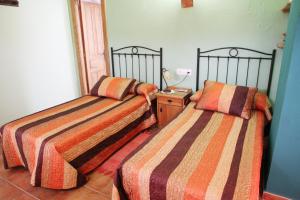 A bed or beds in a room at Hotel Rural Valle del Tuejar
