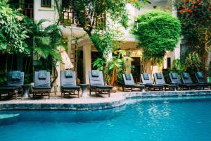 Un grupo de sillas junto a una piscina. en Urban Residences - Siem Reap, en Siem Reap