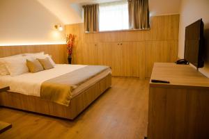 a bedroom with a large bed and a television at Reve Mariage in Bucharest