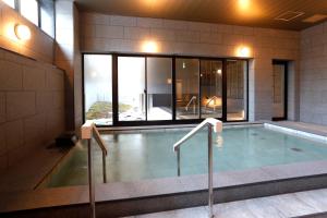 a swimming pool in a building with a large window at Hotel Keihan Kyoto Hachijoguchi in Kyoto