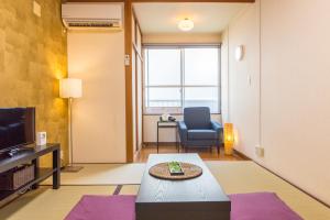 金沢市にあるバケーションレンタルサニーハイツのリビングルーム(ソファ、テーブル、テレビ付)