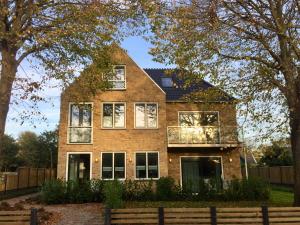 a brick house with a balcony on the front of it at Hotel Graaf Bernstorff in Schiermonnikoog