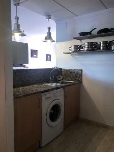 a kitchen with a washing machine and a sink at Lo Chalet in Les Cases d'Alcanar