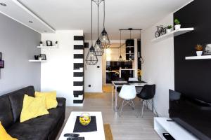 un soggiorno con divano nero e tavolo di Park Apartment a Novi Sad