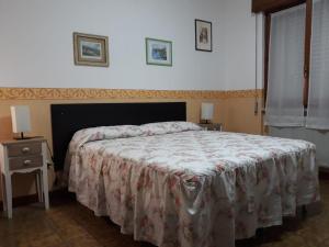 um quarto com uma cama com uma colcha floral e uma mesa de cabeceira em Giangurgolo B&B em Rende