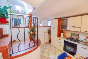 a kitchen with white cabinets and a stove top oven at Casa Bellavista in Terzorio