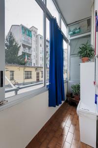 a bathroom with a window with a blue curtain at Apartment Silvia in Turin