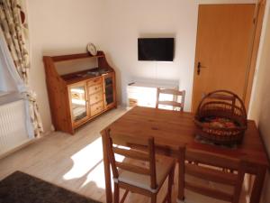 een eetkamer met een tafel en stoelen en een televisie bij Ferienwohnung Simone in Radebeul