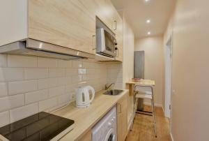 a small kitchen with a sink and a counter at Suites by Riga Old Town in Riga +39 photos