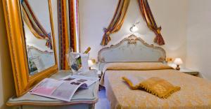 - une chambre avec un lit et un miroir dans l'établissement Hotel Henry, à Venise