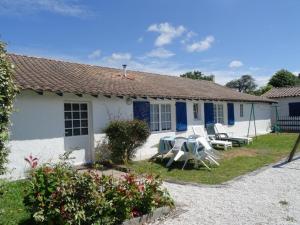 a cottage with a table and chairs in front of it at Les Cigales du Bassin in Gujan-Mestras