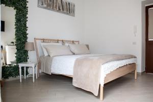 a white bedroom with a bed and a plant at Vicolo 8 in Sorrento
