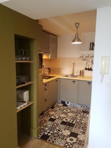 eine Küche mit schwarzweißem Fliesenboden in der Unterkunft Duplex 50 m2 au pied des planches in Trouville-sur-Mer