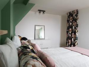 Schlafzimmer mit einem Bett und einem Spiegel in der Unterkunft Duplex 50 m2 au pied des planches in Trouville-sur-Mer