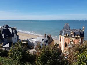 un grupo de edificios en una playa junto al océano en Duplex 50 m2 au pied des planches en Trouville-sur-Mer