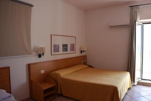 a hotel room with a bed and a window at Hotel Amyclae in Sperlonga