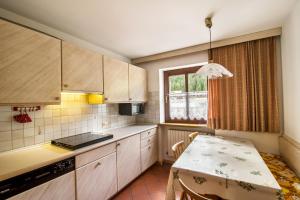 a small kitchen with a table and a window at Casa Matie in Selva di Val Gardena