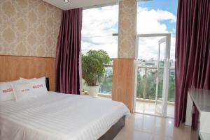 ein Schlafzimmer mit einem Bett und einem großen Fenster in der Unterkunft Ngoc Se Hotel in Pleiku