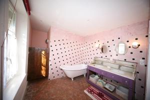 a pink bathroom with a tub and a sink and a tub at Maison d'Hôtes Ferme d'Issonges B&B in Marigny-en-Orxois