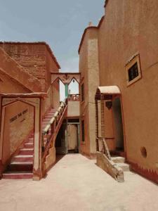 an old building with a staircase next to a building at Kasbah Omari in Tinerhir