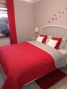 オシフィエンチムにあるApartament FAMILY- klimatyzacjaの赤いベッド1台(赤い毛布付)が備わるベッドルーム1室が備わります。
